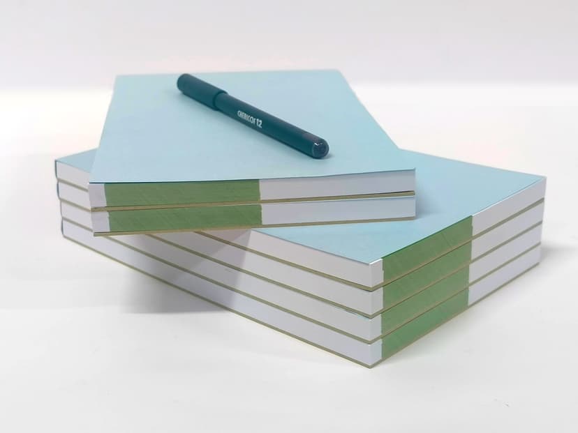 Side view of stacked pads showing the white paper and blue cover