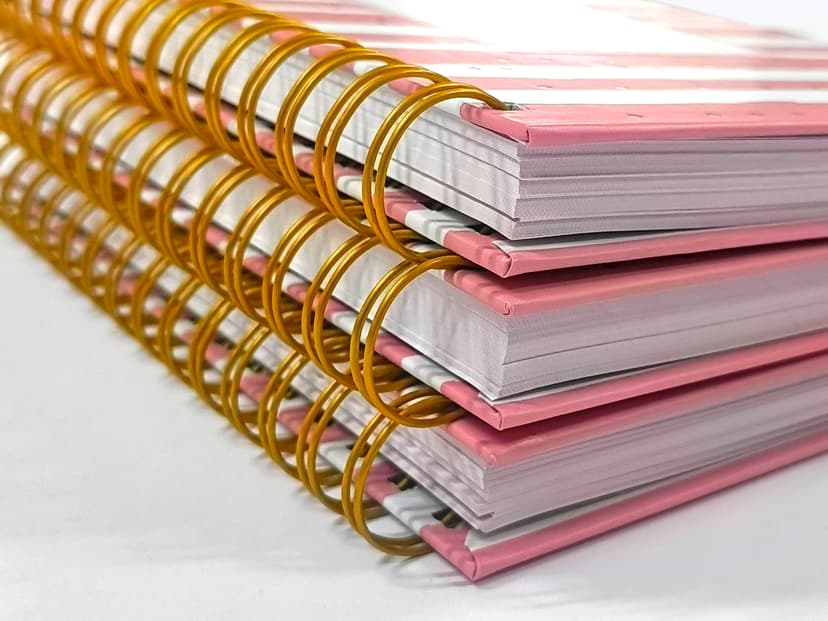 Macro shot of the gold wire-o binding and thick hardcase cover edges.