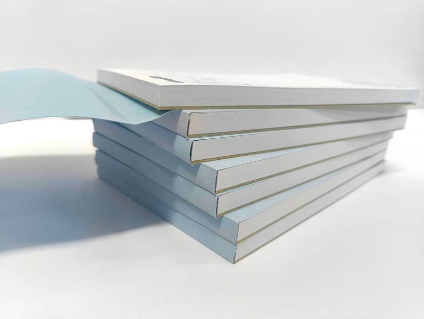 Stacked A5 prescription pads highlighting the glued top edge