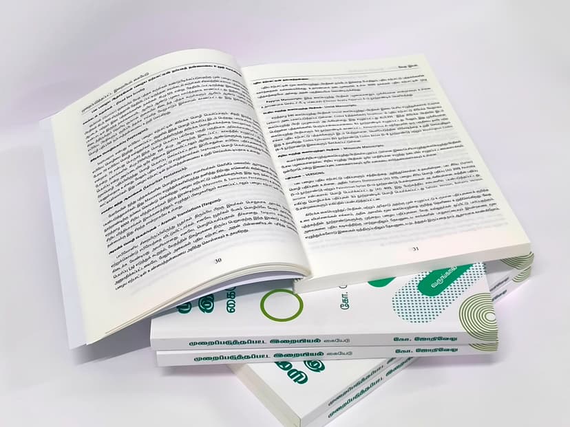 Two textbooks fanned out showing the interior Tamil text and page density.