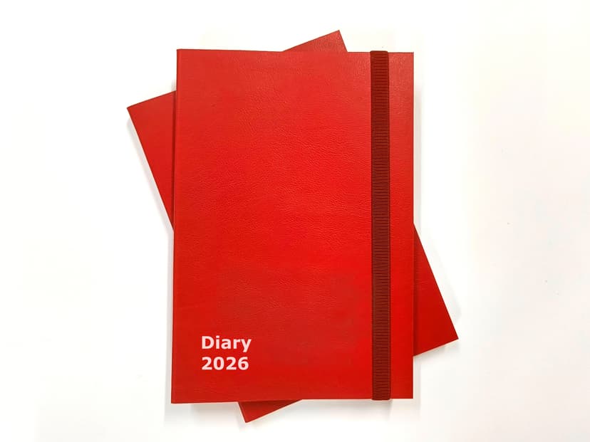 Top-down view of the closed red rexine diary showcasing 'Diary 2026' screen printing.